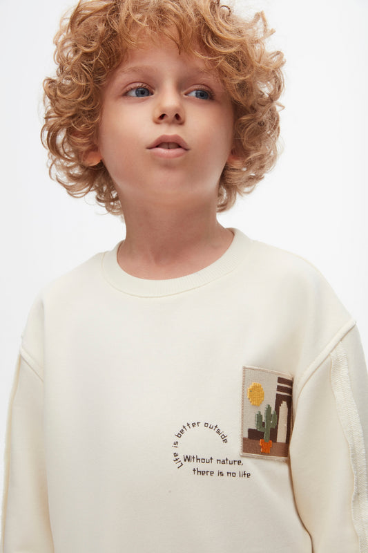 Boys and girls cream sweatshirt.The crew design and soft cotton fabric ensure a comfortable fit.